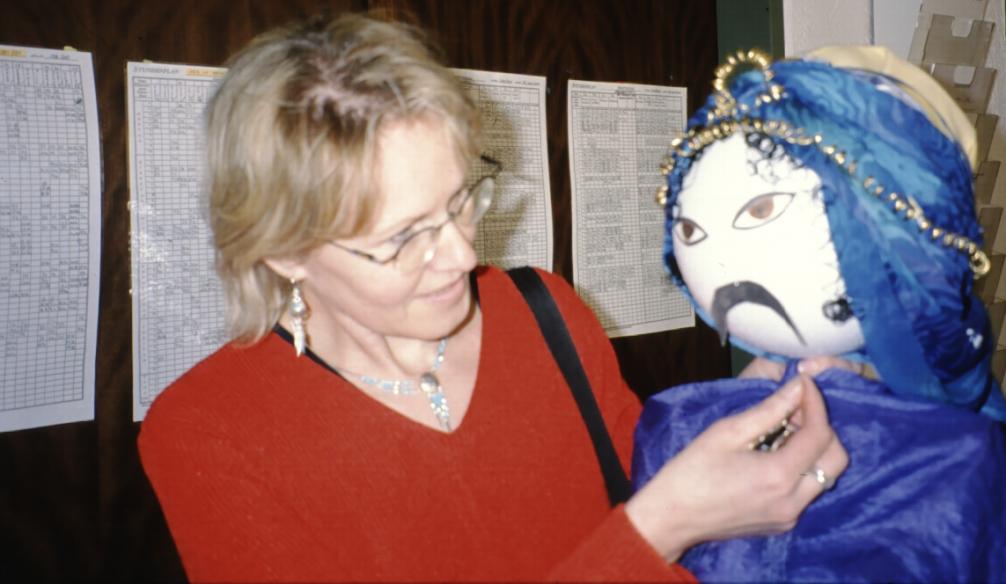 Siess Christine mit rotem Pullover und einer Puppe mit blauer Kleidung in arabischen Stil